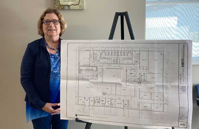 IV Pads Carol Alcorn with blueprint of proposed new building.