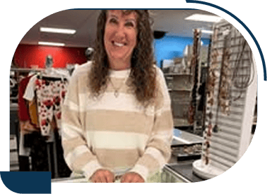 Smiling woman in a boutique clothing store.