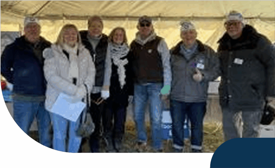 Group photo at outdoor event under a tent.
