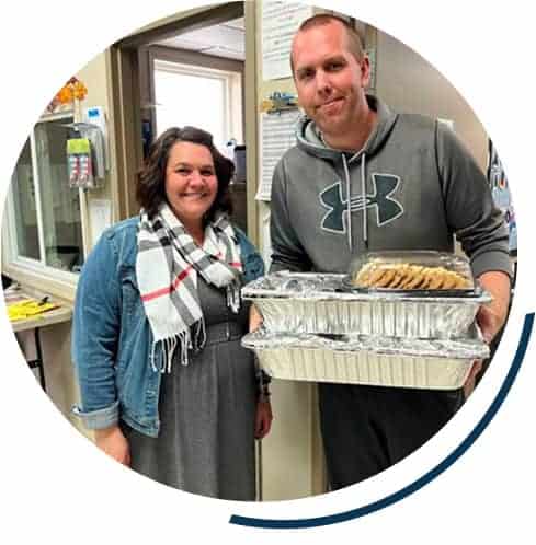 Two people holding trays of food indoors