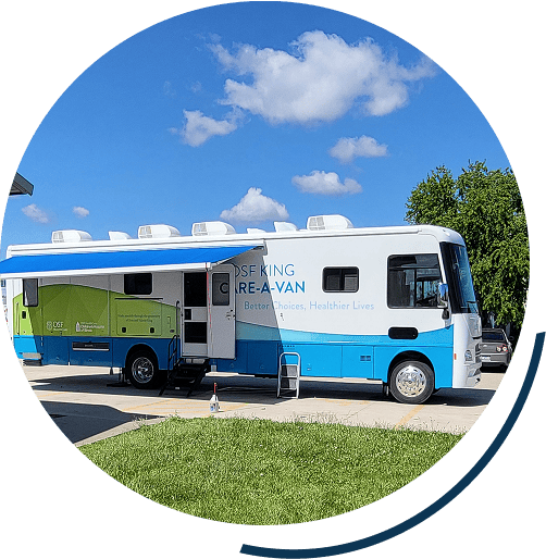 Mobile healthcare van parked under blue sky.
