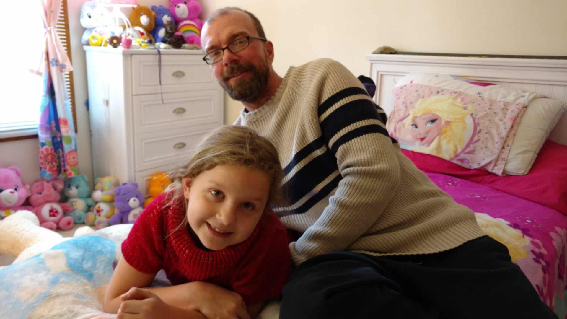 Man and child in colorful bedroom, smiling.