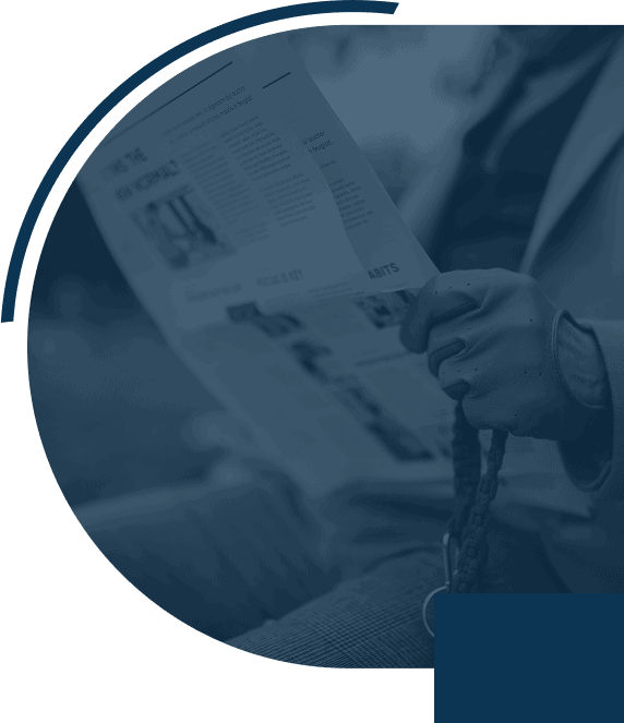 Person reading a newspaper outdoors.
