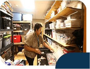Person organizing storage room with boxes and shelves.