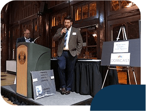 Two men speaking at an event podium.