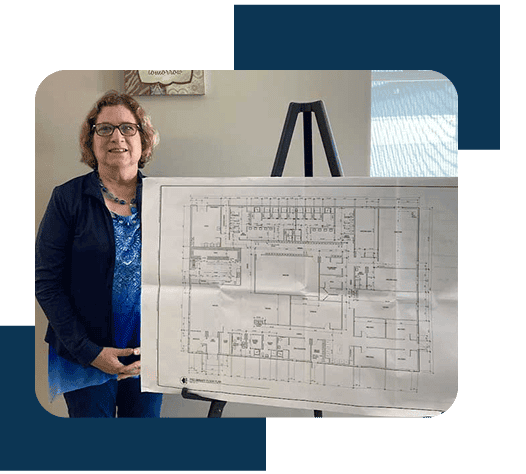 Person presenting architectural blueprint on easel.