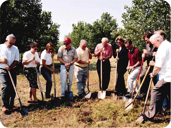 Group of people with shovels at groundbreaking event.