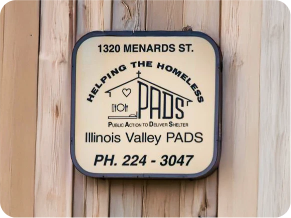 Illinois Valley PADS homeless shelter contact information sign.